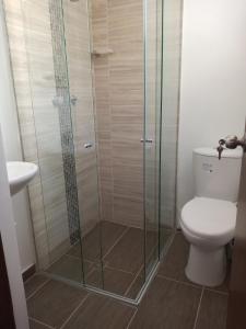 a bathroom with a toilet and a glass shower at Estadio APARTE HOTEL 203 in Medellín