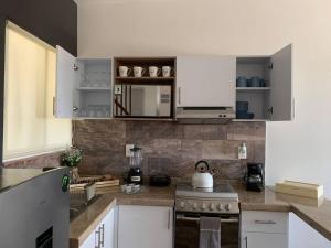 a kitchen with white cabinets and a stove top oven at Departamento completo y equipado con 2 habitaciones in León