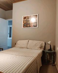 a bedroom with a bed and a picture of donuts on the wall at Artemis House in Krokeaí