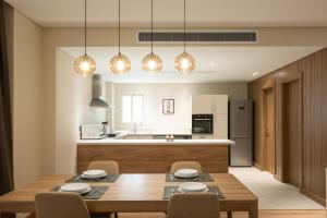 a kitchen and dining room with a wooden table and chairs at New Cairo, Akoya Residence, Milena in New cairo