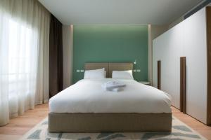 a bedroom with a large white bed with green walls at New Cairo, Akoya Residence, Milena in New cairo