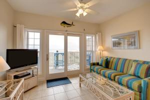 sala de estar con sofá y TV de pantalla plana en Ocean Breezes 863 #110DS-H, en Hatteras