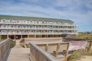a hotel on the beach with a wooden walkway and a building at Ocean Breezes 863 #110DS-H in Hatteras