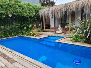 Villa con piscina azul frente a una casa en Hotel Boutique La Mexicana Suites & Beach, en Punta del Este