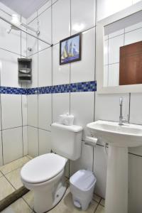 a white bathroom with a toilet and a sink at Estalagem 11 Suites in Arraial do Cabo +43 photos