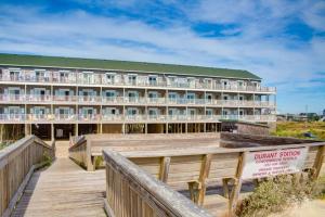un hotel en la playa con un paseo marítimo de madera en Nelton's Nest 815 #201DS-H, en Hatteras