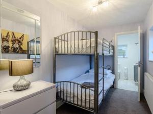 a bedroom with two bunk beds and a mirror at THE HIDEOUT, a Detached Lodge, Hot Tub, Heating, WiFi & Parking in Long Bredy