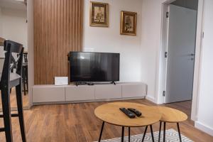 a living room with a flat screen tv on a white cabinet at Mountain Chalet Kopaonik in Kopaonik