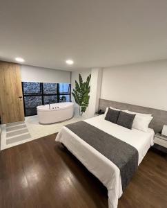 um quarto com uma cama grande e uma banheira em Hotel Piedras De Maní em Manizales