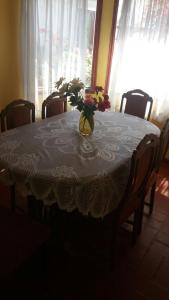 una mesa de comedor con un jarrón de flores. en Casa Norma santiago 8 personas en Santiago