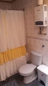 baño con aseo blanco y cortina amarilla en Casa Norma santiago 8 personas en Santiago