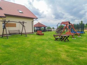 einen Park mit einem Spielplatz mit Bänken und Schaukeln in der Unterkunft Wichrowe Wzgórze in Krajno Pierwsze