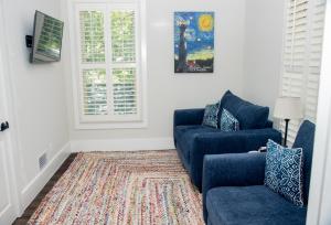 a living room with two blue couches and a rug at Pomar House in St. Augustine