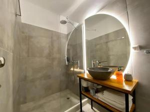 y baño con lavabo y ducha. en AVALON Luxury Suites, en Ermoupoli