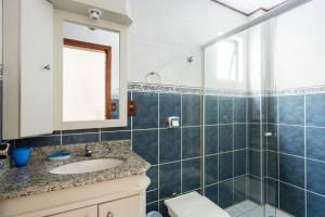 a bathroom with a sink and a toilet and a mirror at Itapema Beira Mar in Itapema +31 photos