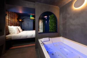 a bathroom with a tub and a bed in a room at Minamina, chambre avec jacuzzi privatif in Roquefort-la-Bédoule +46 photos