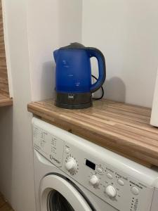 einen Wasserkocher mit blauem Tee auf der Waschmaschine in der Unterkunft Mały apartament z kuchnią i łazienką in Stettin