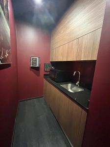 a bathroom with a sink and red walls at Legend Majestic Superbe Love Room - Jacuzzi - Champagne - Romantisme - parking privé GRATUIT in Mâcon +5 photos