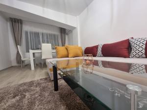 un soggiorno con divano e tavolo in vetro di DREAMS ESCAPE 2 a Craiova