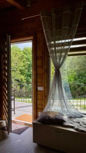 a bedroom with a window with a curtain on it at Mon Resort by Ana1St in Scărişoara