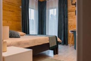 a bedroom with a bed and a large window at Mon Resort by Ana1St in Scărişoara