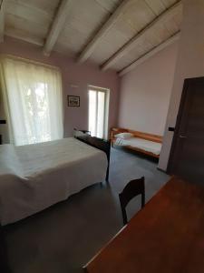 Schlafzimmer mit einem Bett, einem Tisch und einem Fenster in der Unterkunft Rosatea B&B in Chieri
