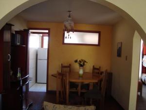 a dining room with a table with a vase of flowers at casa norma santiago 5 personas in Santiago