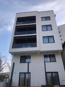 a tall white building with black windows at DREAMS ESCAPE 2 in Craiova