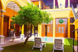 a house with two chairs and a tree in the yard at Hotel Real Toledo by Kavia in Mérida