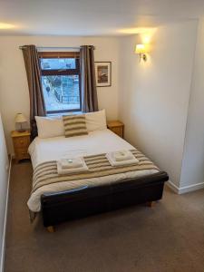 1 dormitorio con 1 cama grande y ventana en Ferry Inn, en Stromness