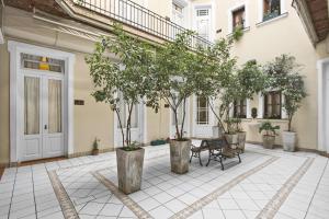 a courtyard with trees and a bench in front of a building at Milhouse Hostel Hipo in Buenos Aires