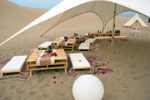 a tent with tables and chairs in the desert at Duna Camp Huacachina in Ica