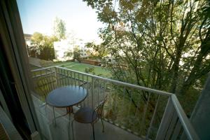 a balcony with a table and a chair on a porch at Le Boudoir, Centre ville, Parking couvert inclus in Mulhouse