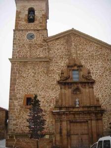 un edificio de ladrillo con una torre del reloj y un árbol de Navidad en Precioso apartamento con vistas en Valedlinares, en Valdelinares