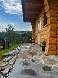 a bench sitting on a porch of a log cabin at MamChwilkeHome in Istebna