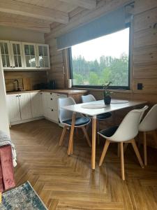 cocina con mesa, sillas y ventana en MamChwilkeHome, en Istebna