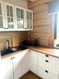 a kitchen with white cabinets and a sink at MamChwilkeHome in Istebna +19 photos
