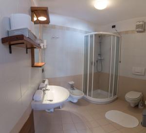 uma casa de banho com um lavatório, um chuveiro e um WC. em Gästehaus Schwabach em Schwabach