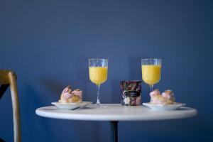 a table with two glasses of orange juice and desserts at Le Boudoir, Centre ville, Parking couvert inclus in Mulhouse