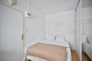 een witte kamer met een bed en een spiegel bij 33#Studio 2Pers#Sèvres-Lecourbe#Necker in Parijs +5 foto's