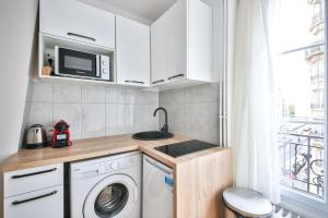 een kleine keuken met een wasmachine en een wastafel bij 33#Studio 2Pers#Sèvres-Lecourbe#Necker in Parijs