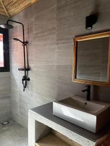 La salle de bains est pourvue d'un lavabo et d'un miroir. dans l'établissement Terra Lodge Sénégal, à Mbour