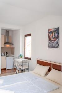 a bedroom with a bed and a kitchen with a table at Apartments Serafimoski in Ohrid