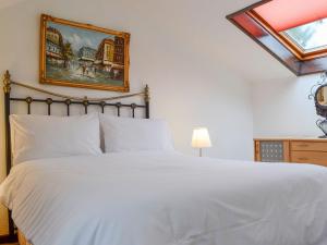 Llangeinor的住宿－Penny Croft - Uk10449，卧室配有白色的床和墙上的绘画作品