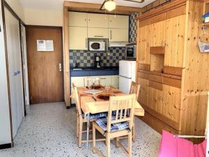 una pequeña cocina con mesa de madera y sillas en Studio Balaruc-les-Bains, 1 pièce, 2 personnes - FR-1-503-103, en Balaruc-les-Bains
