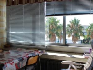 a room with a table and a window with palm trees at Appartement Balaruc-les-Bains, 2 pièces, 4 personnes - FR-1-503-118 in Balaruc-les-Bains