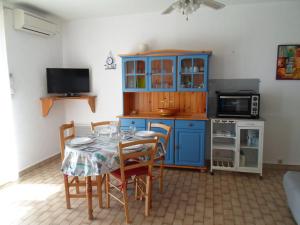 eine Küche mit einem Tisch mit Stühlen und einem blauen Schrank in der Unterkunft Appartement Balaruc-les-Bains, 2 pièces, 4 personnes - FR-1-503-122 in Balaruc-les-Bains