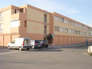 ein Gebäude mit Autos auf einem Parkplatz in der Unterkunft Appartement Balaruc-les-Bains, 2 pièces, 4 personnes - FR-1-503-122 in Balaruc-les-Bains