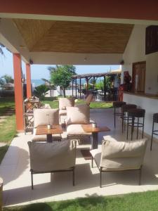 un patio con sillas y mesas blancas, mesa y sillas en Terra Lodge Sénégal, en Mbour