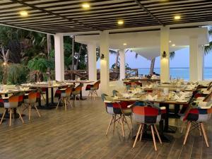 un restaurante con mesas y sillas con el océano en el fondo en Shooting Star Boutique Hotel en Kiwengwa